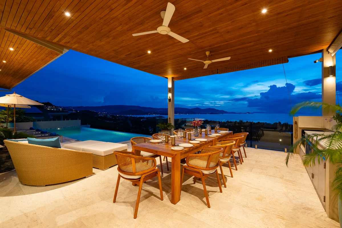 The covered dining terrace overlooking the sea at dusk