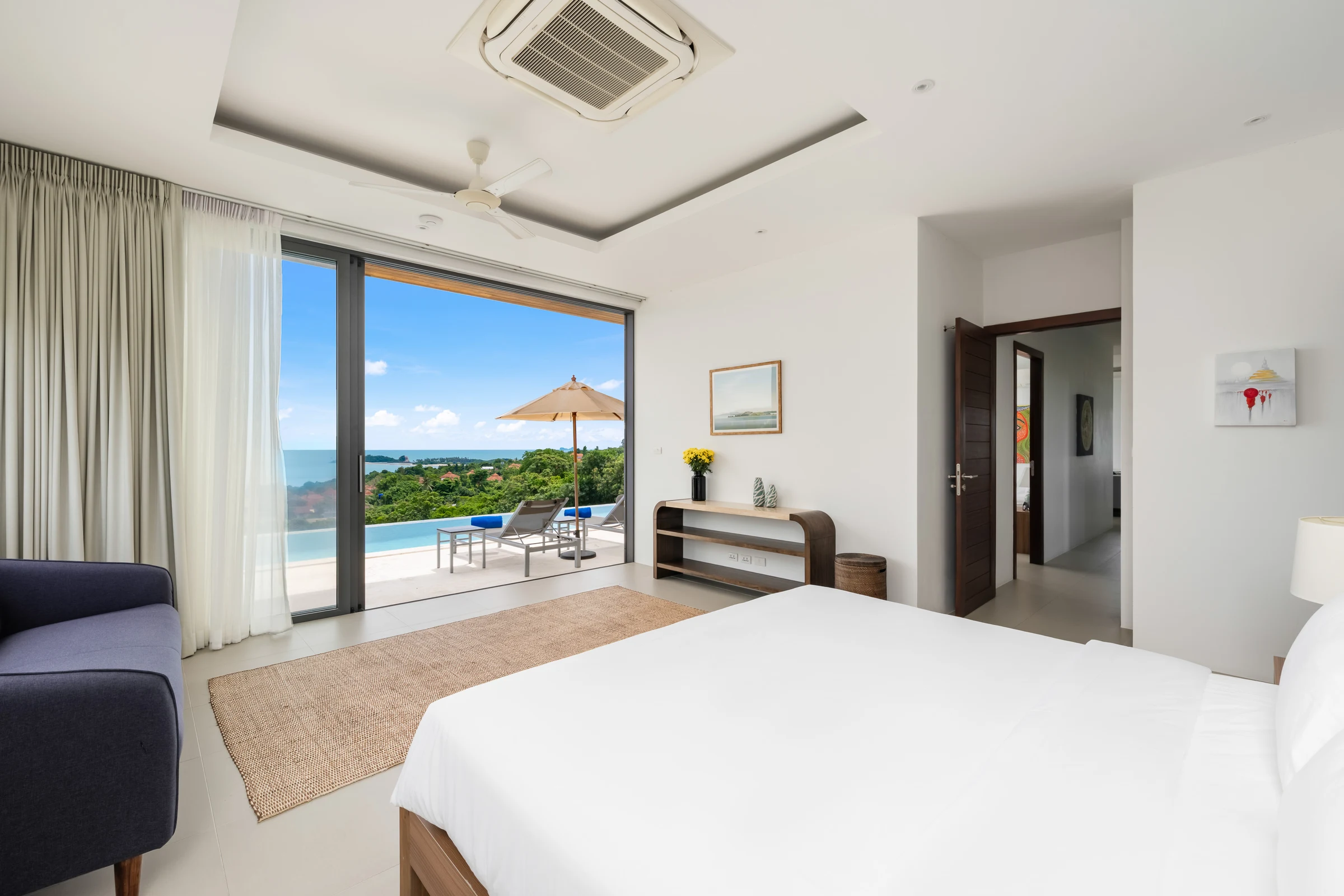 The master bedroom opening towards the pool and sea